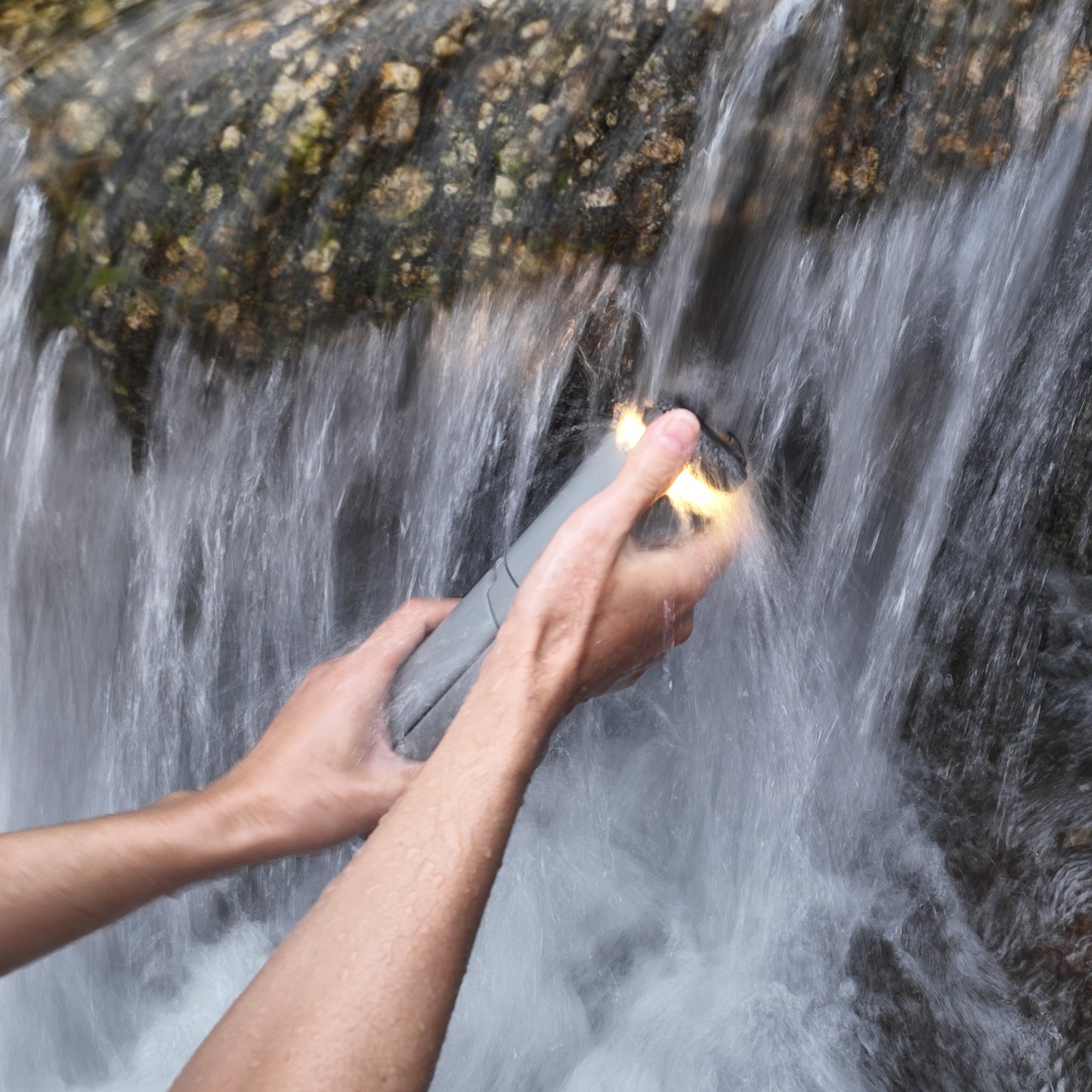 Wasserdichte Lampe wird unter Wasserfall sauber gemacht und leuchtet
